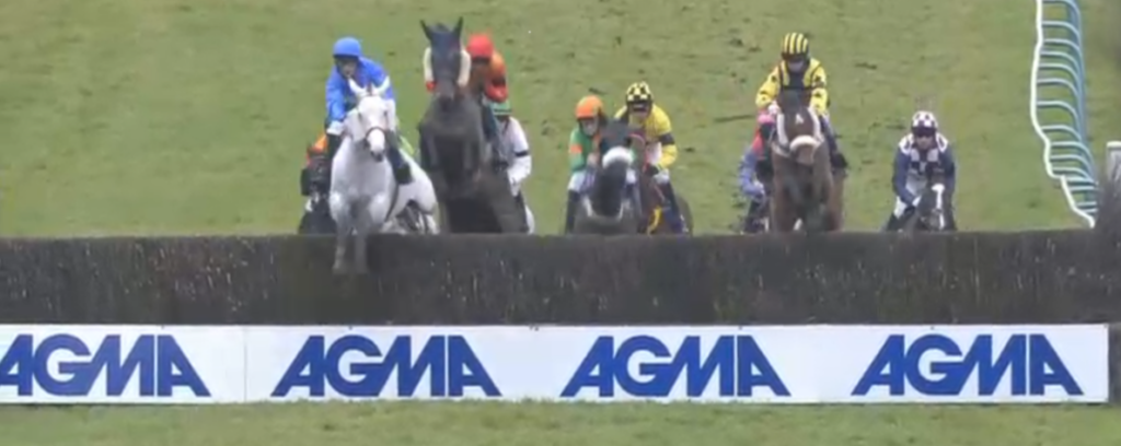 Racehorse jockeys jumping over jump fence with AGMA sponsors